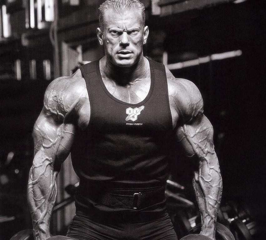 Dennis Wolf posing for a photo in a black tank top, looking ripped and vascular