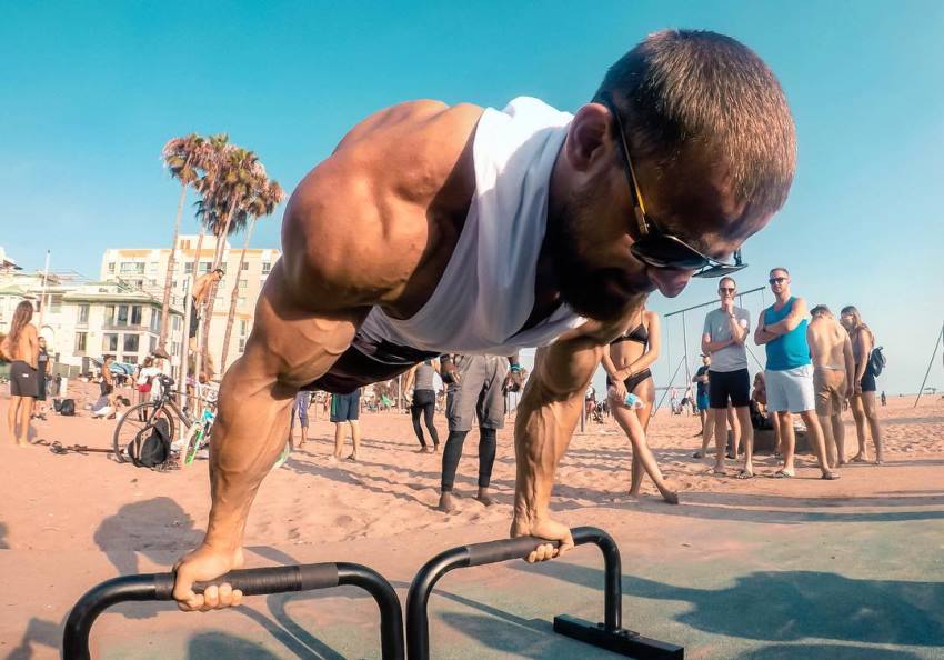 Islam Badurgov doing exercises on the bar on the beach