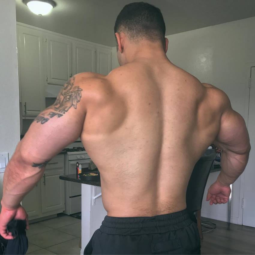 Jamie LeRoyce flaring his arms and lats out, showing his muscular back