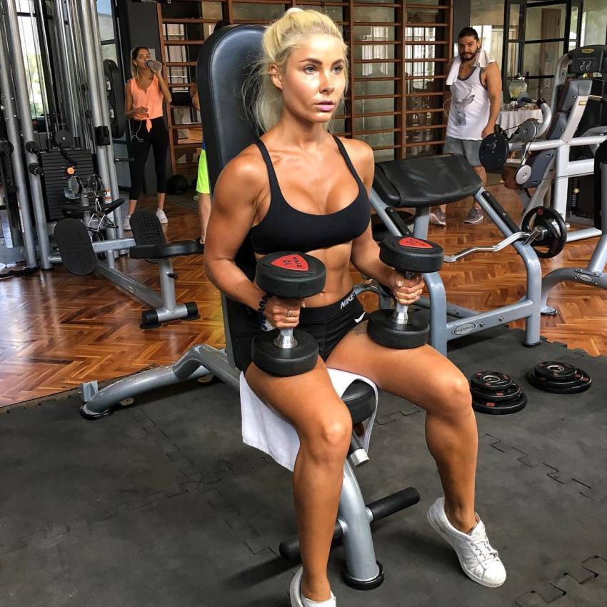 Jaz Correll preparing to do an exercise with dumbbells in the gym