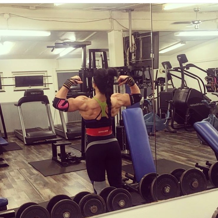 Mariana Mayakonda flexing her muscular back in the gym, showing a back double biceps pose