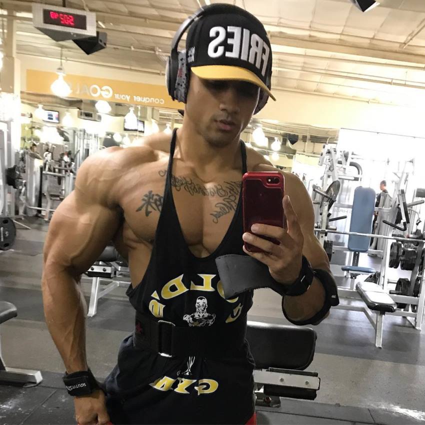 Marvin Moss III taking a photo of his ripped physique in a gym