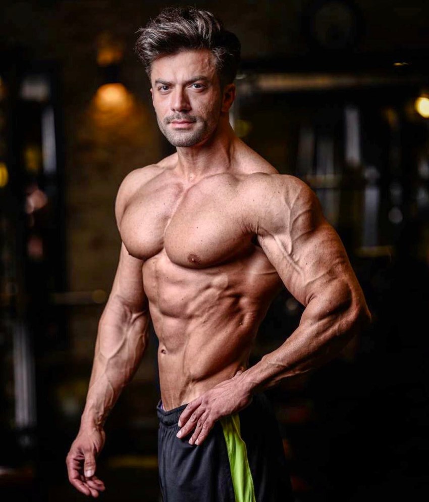 Mohammad Kashanaki posing for the picture, showing his ripped arms and shoulder, chest, abs, and obliques