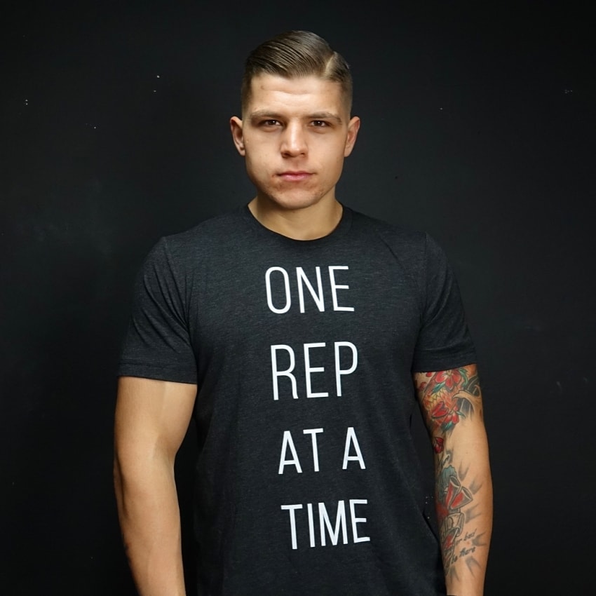 ObesetoBeast posing for a photo in a black shirt with motivational quote "One Rep at a time"