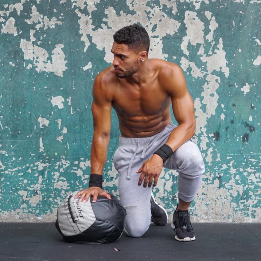 Ryan Tremaine Klarenbach kneeling with a medicine ball by his arm