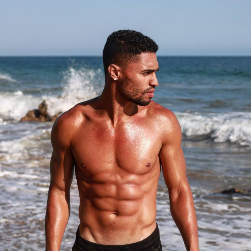 Ryan Tremaine Klarenbach standing shirtless by the sea
