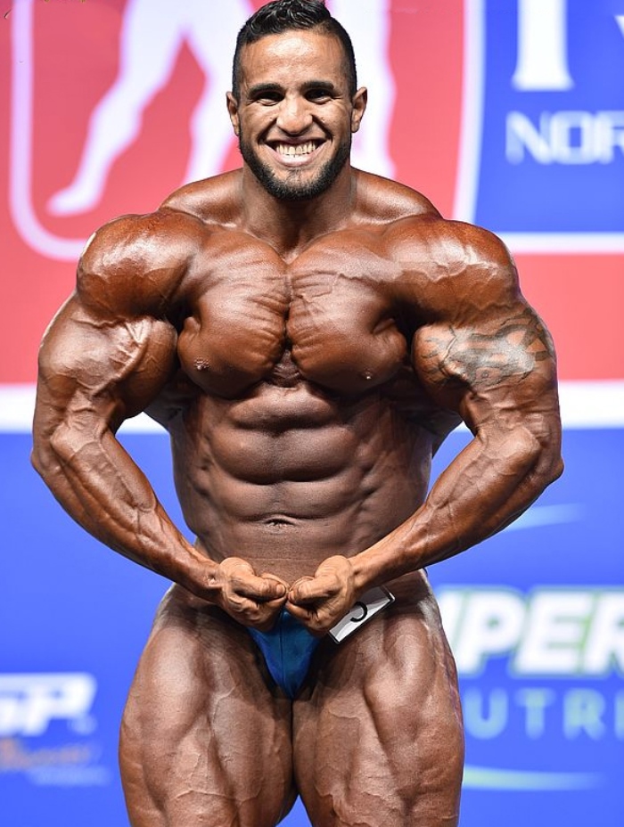 Abdelaziz Jellali flexing his muscles in a bodybuilding contest in front of an audience