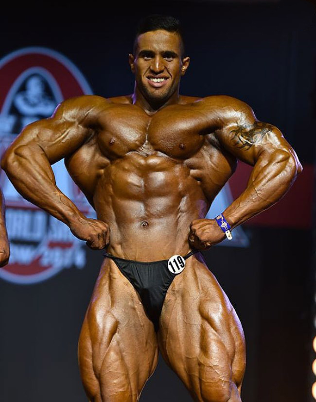 Abdelaziz Jellali spreading his lats in front of the judges on the stage