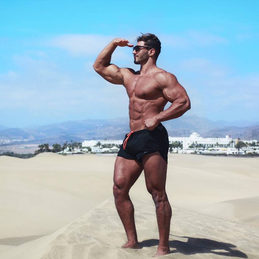 Amin Elkach flexing his biceps on the beach
