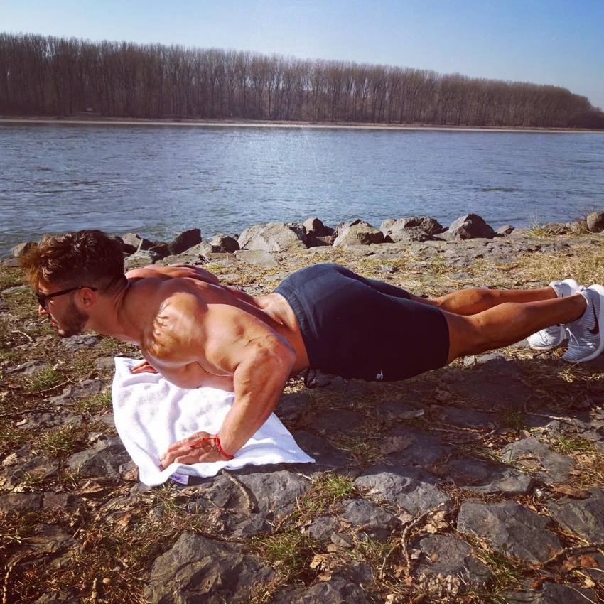 Amin Elkach doing pushups on a towel by the river.