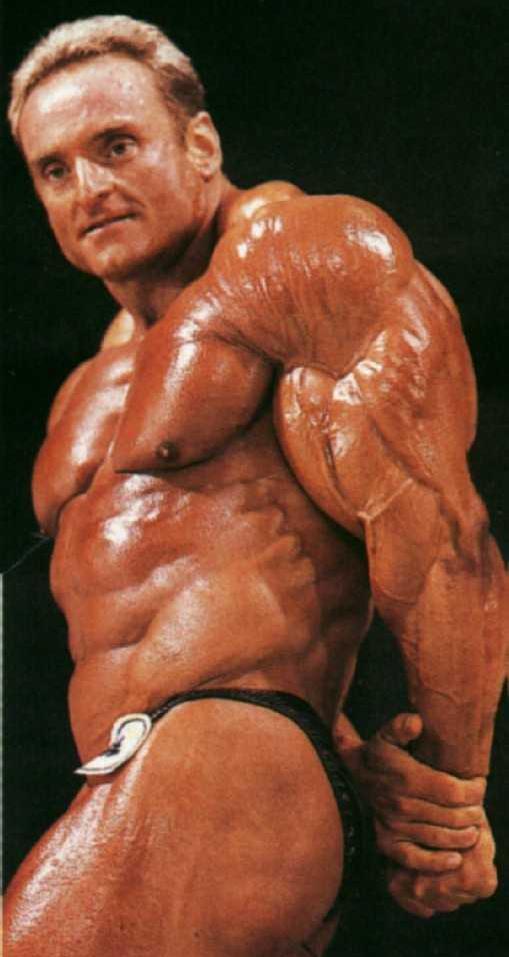 Andreas Munzer flexing his triceps on the stage