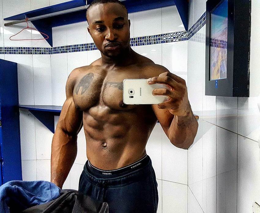 Antonio Mitchell taking a selfie of his muscular chest, arms, and chiseled abs