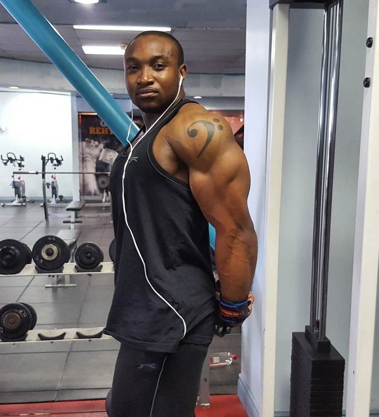 Antonio Mitchell flexing his ripped triceps in the gym