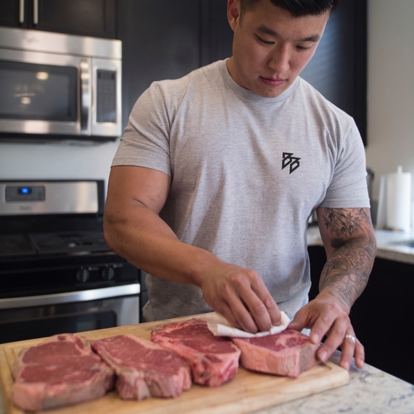 Bart Kwan preparando carne vermelha em sua casa