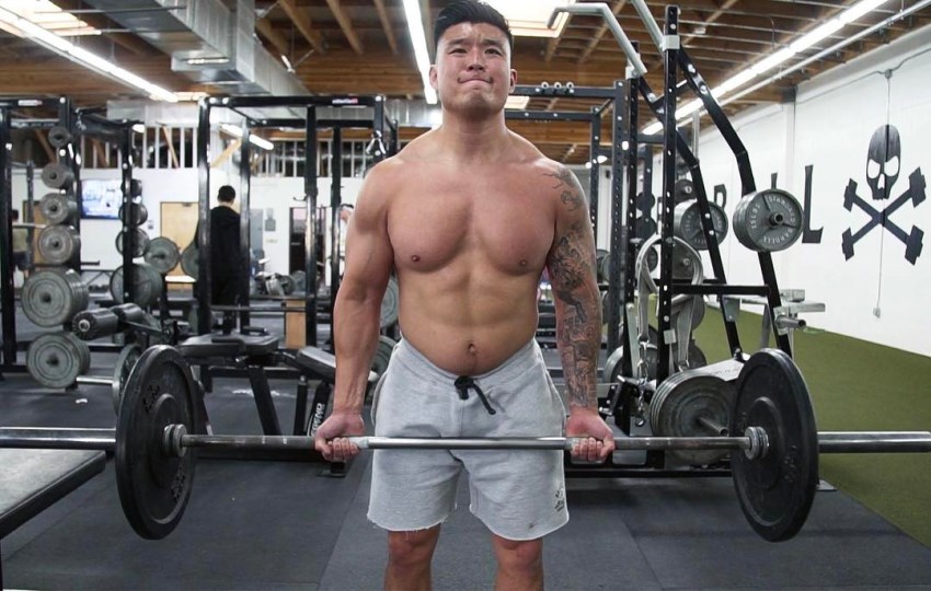 Bart Kwan doing heavy barbell curls in the gym