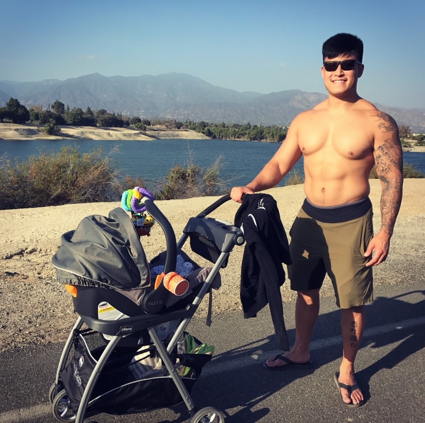 Bart Kwan walking shirtless with his son in a baby stroller, looking lean and fit
