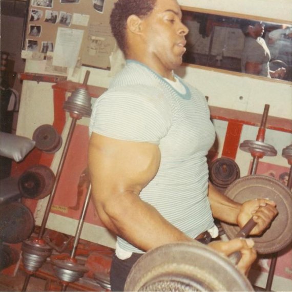 Bill Pettis performing a bicep curl with a barbell.