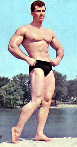 Bob Gajda posing outside by the lake, looking muscular