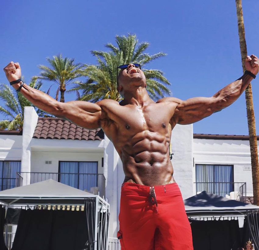 Brandon Carter holding his arms out, showing off his ripped physique.