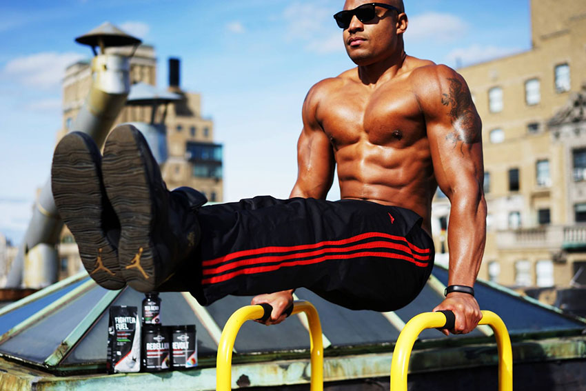 Brandon Carter performing an exercise on parallel bars.