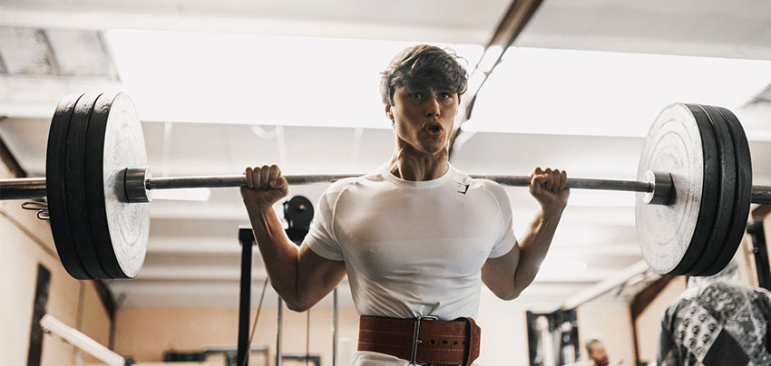 David Laid performing squats in the gym.