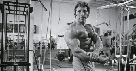 Eddie Giuliani doing a side chest pose in a gym, looking big and ripped