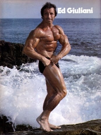 Eddie Giuliani flexing by the sea, looking ripped