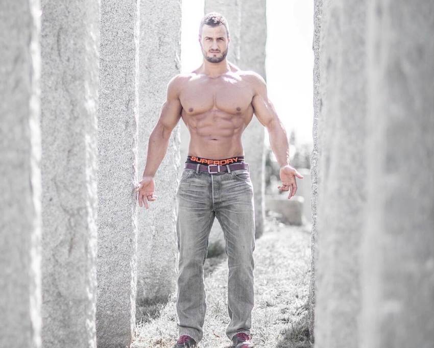 Emil Goliath posing shirtless in grey jeans for the camera