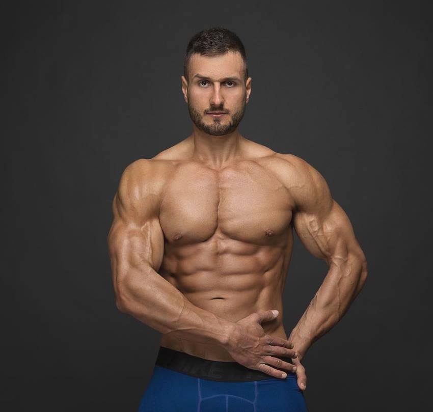 Emil Goliath posing directly in front of the camera, looking lean and aesthetic