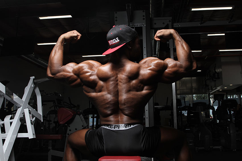 Gerald Williams showing off his back muscles flexing his arms.