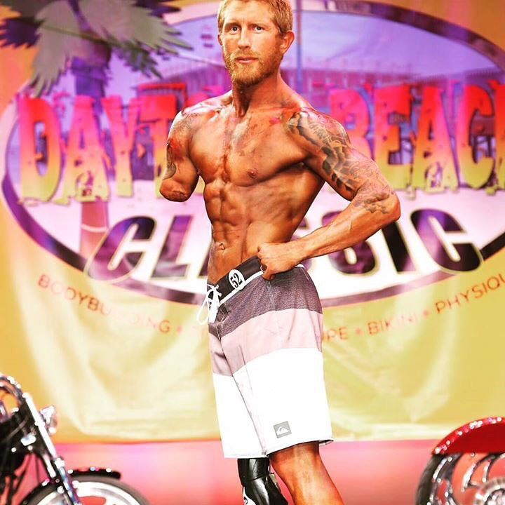 Jared Bullock on stage at a bodybuilding competition.,