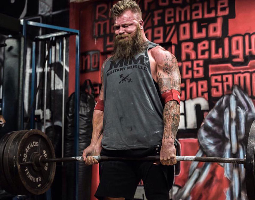 KC Mitchell performing a deadlift in the gym.