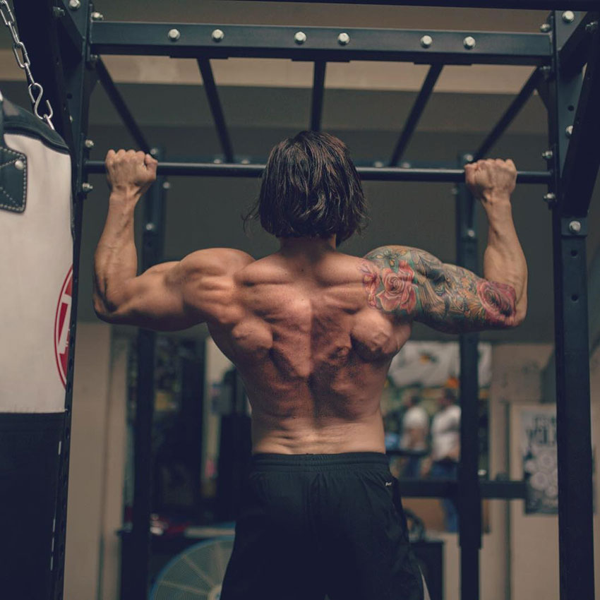 Lex Griffin performing a pull up showing off his back muscles.
