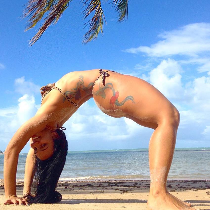 Lorrane Ottoni doing stretches on the beach