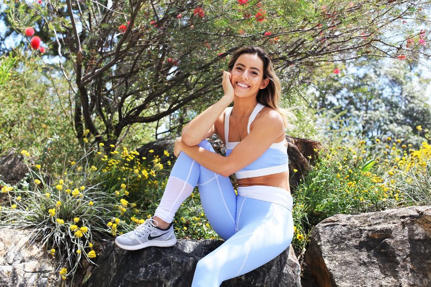 Madalin Giorgetta Frodsham sitting down on a rock in sportswear and smiling at the camera
