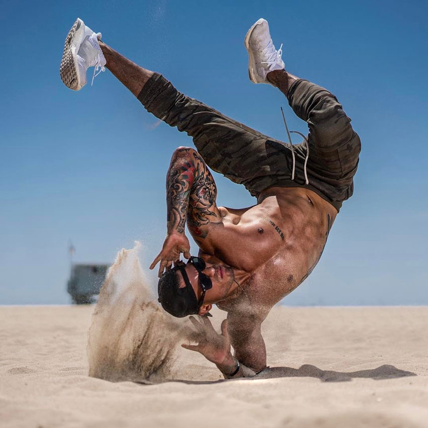 Michael Vazquez performing a break dancing move on the beach.