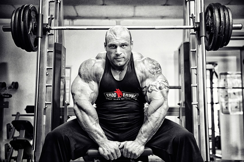Morgan Aste sat on smith machine flexing off his arms