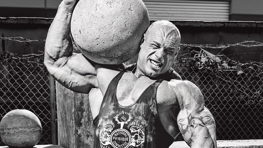 Morgan Aste carrying an atlas stone at a strongman event