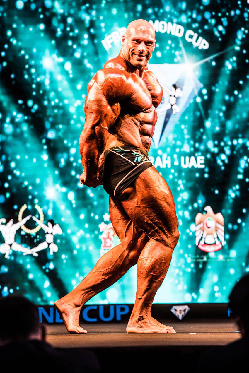 Morgan Aste flexing his muscles at a competition