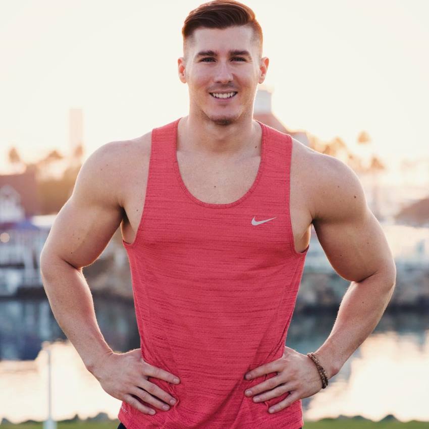 Nimai Delgado smiling for the photo, wearing red tank top