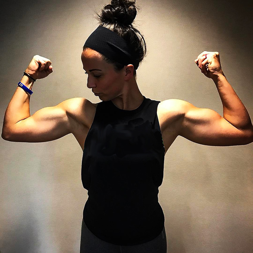 Sarah Bowmar flexing both biceps