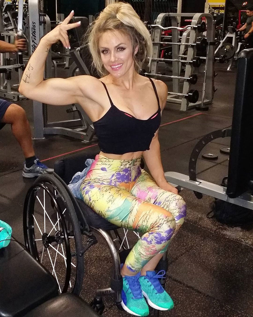 Tiphany Adams flexing her bicep in the gym.