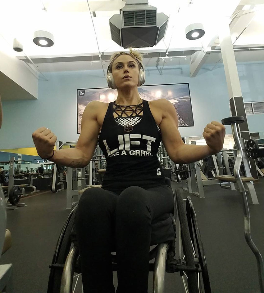 Tiphany Adams tensing her arms in the gym.