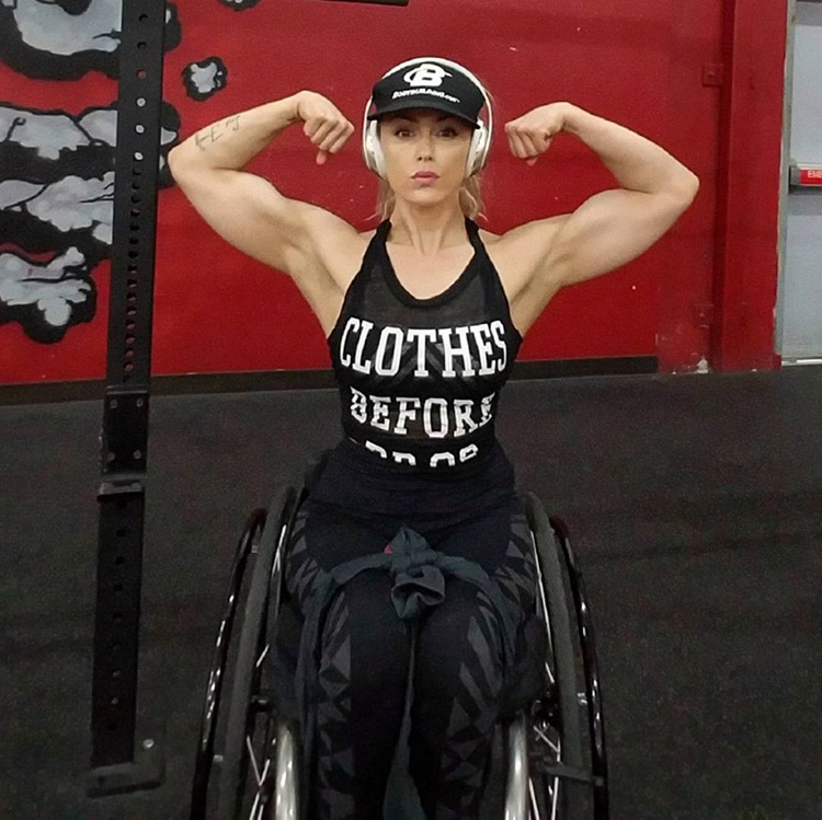 Tiphany Adams flexing both biceps looking strong and lean in the gym