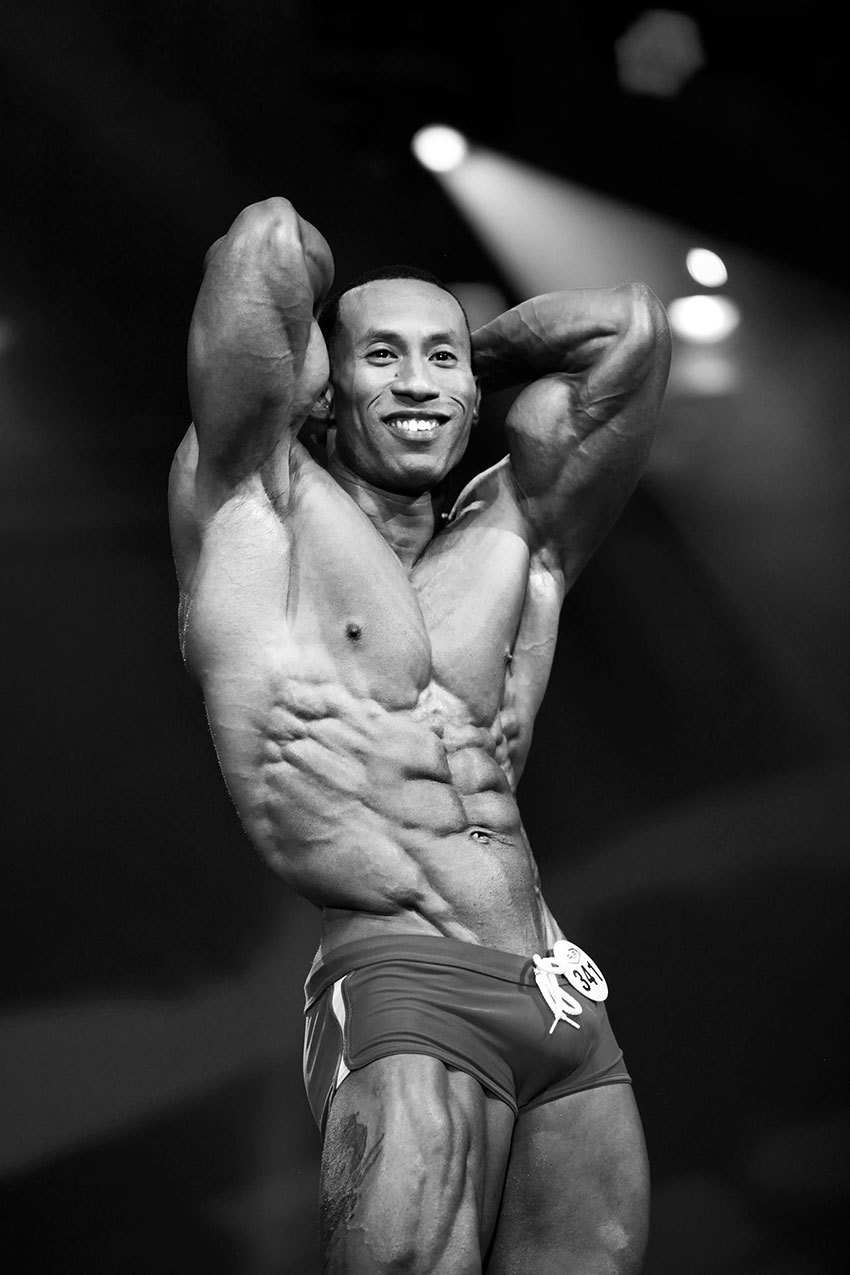 AJ Ellison showing his abs on stage.