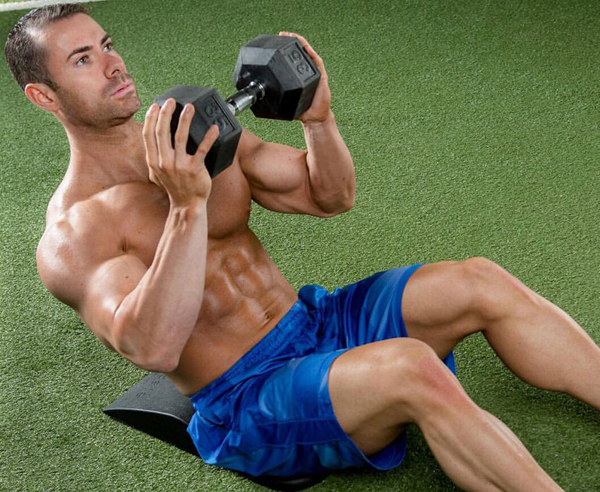 Alex Carneiro exercising in the gym with a dumbbell.