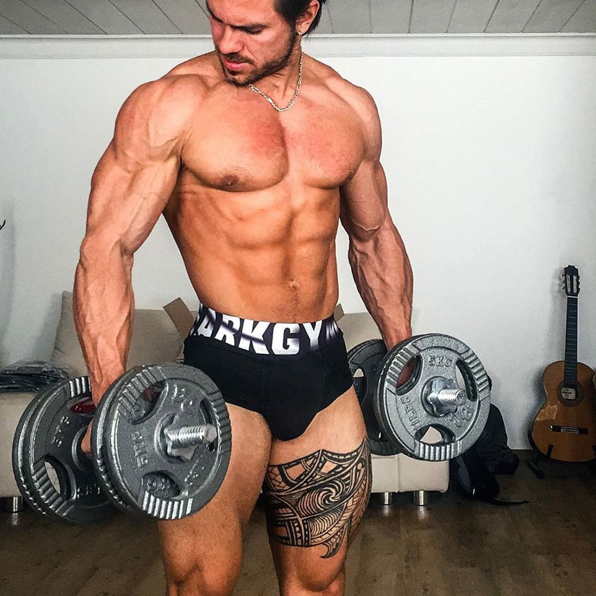 Alon Gabbay holding dumbbells in a photo shoot.