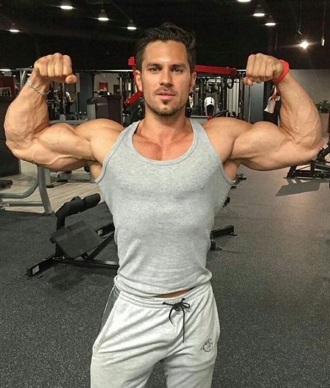 Alon Gabbay flexing his biceps in the gym.