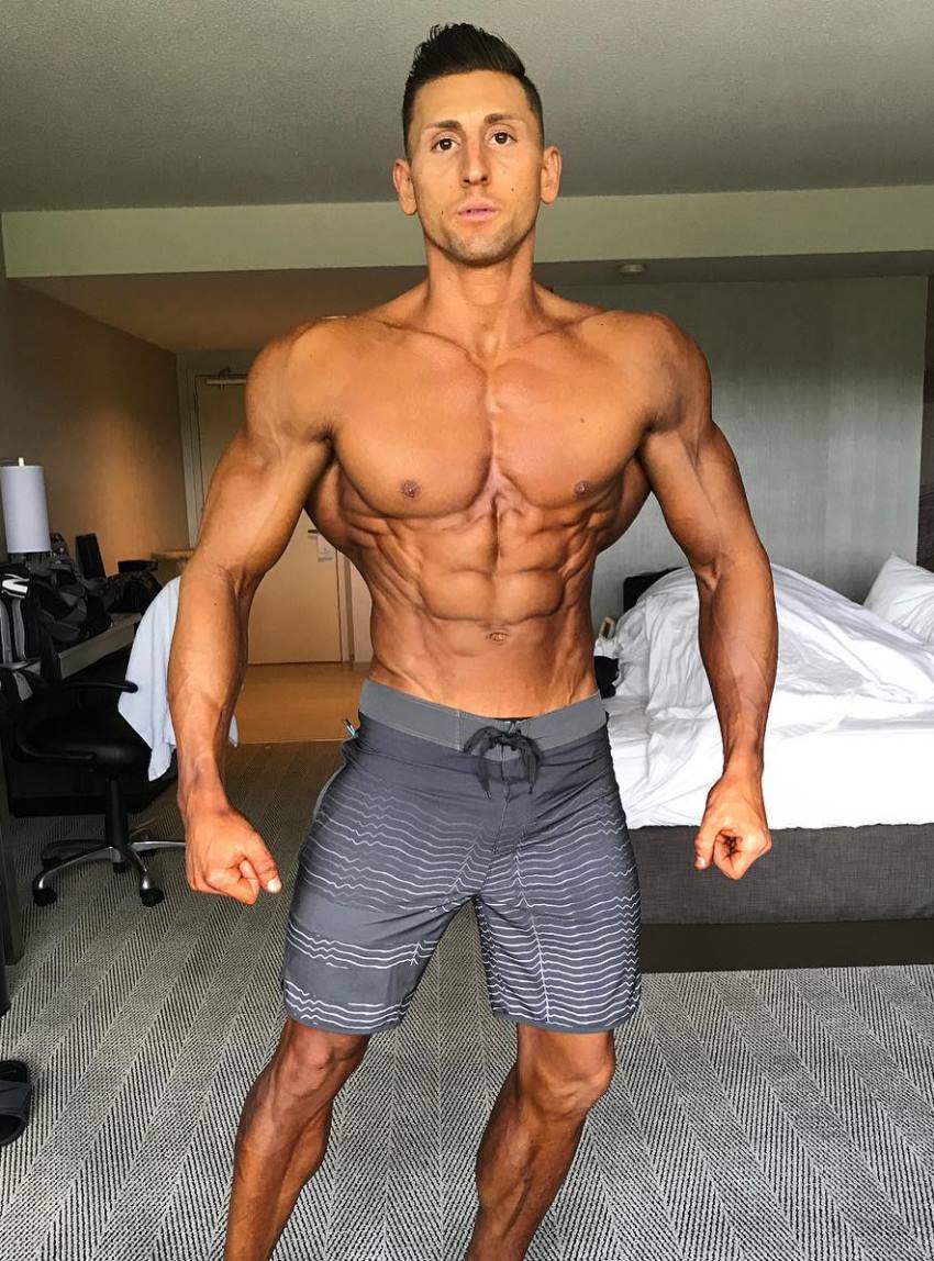 Anthony Scalza posing in his bedroom, practicing his routine for a physique show