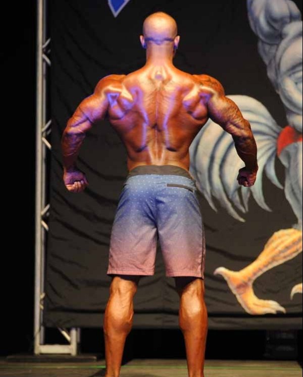 Antoine Williams displaying his back muscles in a men's physique competition